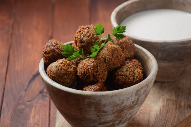 Falafel balls with parsley in wooden bowl with tahini sauce. Vegan healthy food